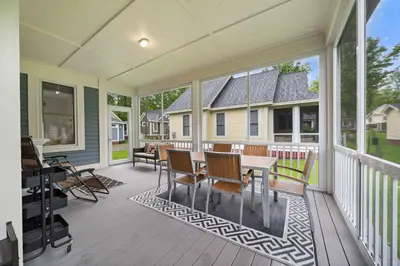 a screened porch with a table and chairs at The Tamarack - 11 Hollow in Cherry Valley