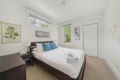 a bedroom with a bed with a cat laying on it at The Tamarack - 11 Hollow in Cherry Valley