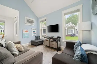 a living room with a couch and a flat screen tv at The Tamarack - 11 Hollow in Cherry Valley