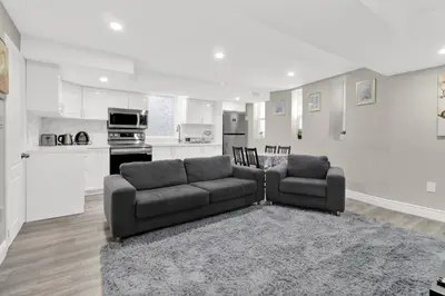 a living room with a couch and a kitchen at Cozy Ancaster Hamilton Apartment in Hamilton