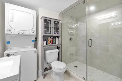 a bathroom with a shower and a toilet and a sink at Cozy Ancaster Hamilton Apartment in Hamilton