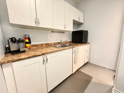 a kitchen with white cabinets and a sink at Steps to Bars & Fun in Port Credit in Mississauga
