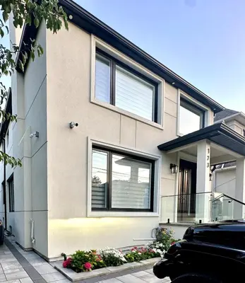 a house with windows and flowers in front of it at Comfortable place In An Amazing Location in Toronto