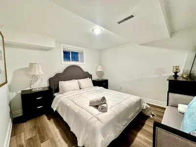 a bedroom with a large bed with a white blanket at Comfortable place In An Amazing Location in Toronto