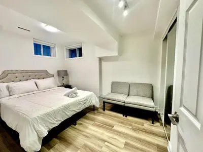a bedroom with a bed and a chair at Comfortable place In An Amazing Location in Toronto