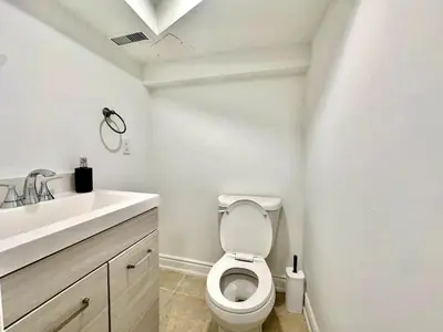 a white bathroom with a toilet and a sink at Comfortable place In An Amazing Location in Toronto