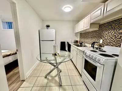a kitchen with a glass table and a white refrigerator at Comfortable place In An Amazing Location in Toronto