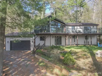 a large house with a porch and a garage at Villa Marina Haven private Waterfront in Port Carling