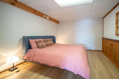 a bedroom with a bed with a pink blanket at Villa Marina Haven private Waterfront in Port Carling