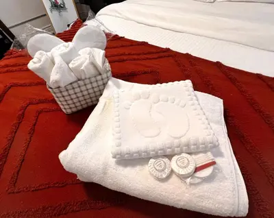 two white towels on a red bed with two baskets at The Downtown Gem Toronto in Toronto