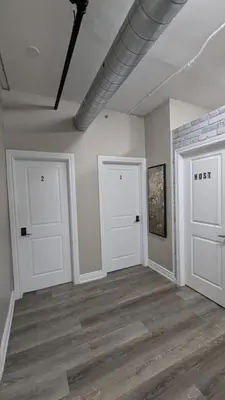 two white doors in a room with wooden floors at The Downtown Gem Toronto in Toronto
