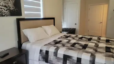 a bedroom with a bed with a black and white quilt at Comfortable Getaway in Hamilton