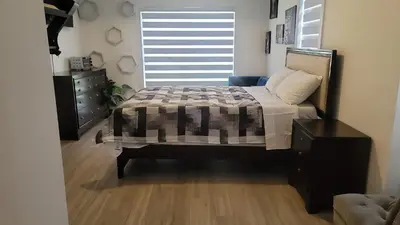 a bedroom with a bed and a dresser and a window at Comfortable Getaway in Hamilton