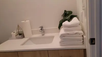 a bathroom with a sink and a stack of towels at Comfortable Getaway in Hamilton