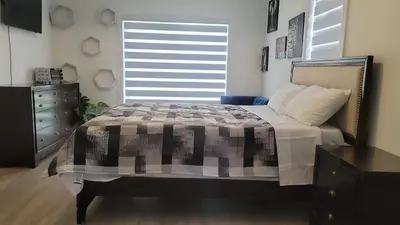 a bedroom with a bed and a dresser and a window at Comfortable Getaway in Hamilton
