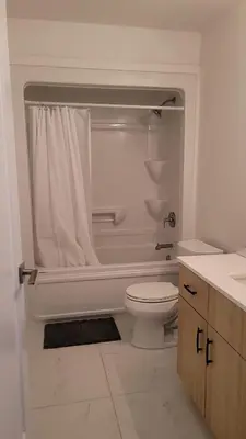 a white bathroom with a toilet and a shower at Comfortable Getaway in Hamilton
