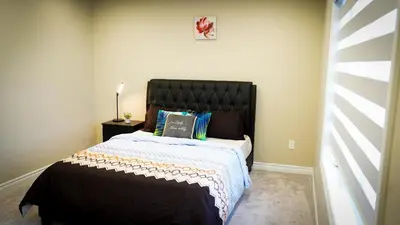 a bedroom with a large bed with a black headboard at Stunning fully furnished detached house 4 Bed Retreat, with complete privacy and comfort, WiFi & Full Kitchen in Paris