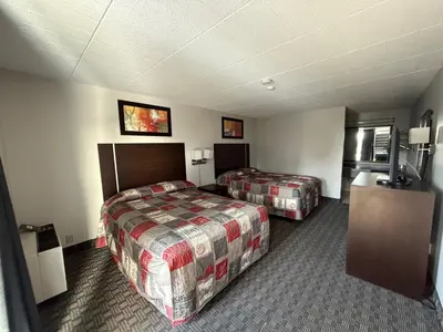 a hotel room with two beds and a television at Fort York Motel in Mississauga