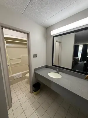 a bathroom with a sink and a mirror at Fort York Motel in Mississauga