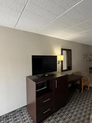 a room with a desk with a flat screen tv at Fort York Motel in Mississauga