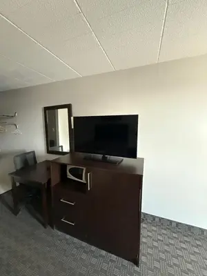 an office cubicle with a desk and a flat screen tv at Fort York Motel in Mississauga
