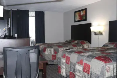 a hotel room with two beds and a chair at Fort York Motel in Mississauga