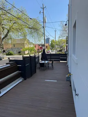 a patio with a table and an umbrella on a building at Adorable Modern Master Bedroom near Colleges and K-town in Toronto