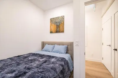 a bedroom with a bed and a painting on the wall at Adorable Modern Master Bedroom near Colleges and K-town in Toronto