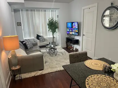 a living room with a couch and a tv at Cozy Ensuite private room homestay in Mississauga