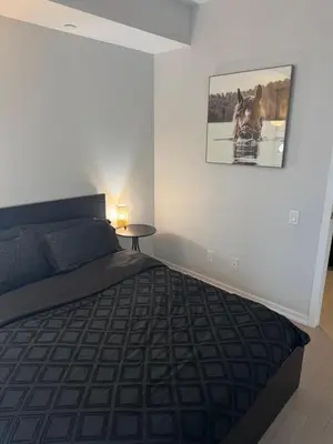 a bedroom with a bed and a picture on the wall at Cozy 1 Bedroom Downtown in Toronto