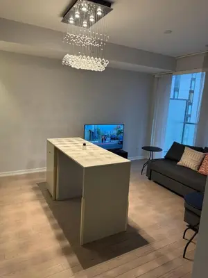a living room with a table and a couch at Cozy 1 Bedroom Downtown in Toronto