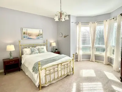 a bedroom with a bed and two windows at Spacious Beach Town Retreat - Sleeps 8 in Port Elgin