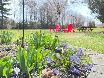 a garden with red chairs and purple flowers in a park at Spacious Beach Town Retreat - Sleeps 8 in Port Elgin