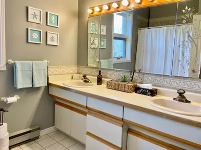 a bathroom with two sinks and a large mirror at Spacious Beach Town Retreat - Sleeps 8 in Port Elgin