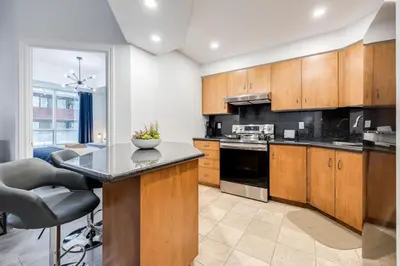 a kitchen with wooden cabinets and a counter top at Modern 1BR and 1BA condo near Downtown with City Views in Toronto