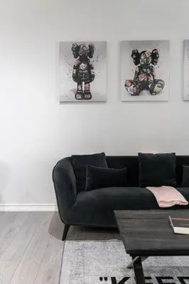 a living room with a black couch and pictures on the wall at Modern 1BR and 1BA condo near Downtown with City Views in Toronto