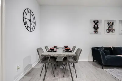 a dining room with a table and chairs and a clock at Modern 1BR and 1BA condo near Downtown with City Views in Toronto