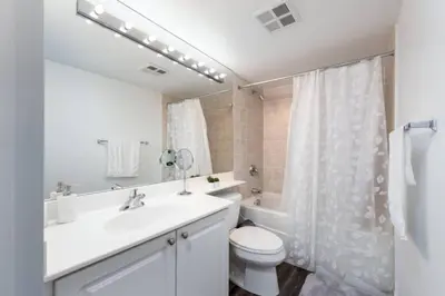 a bathroom with a sink and a toilet and a shower at Chic 1BR Condo Lake and City Views plus Free Parking in Toronto