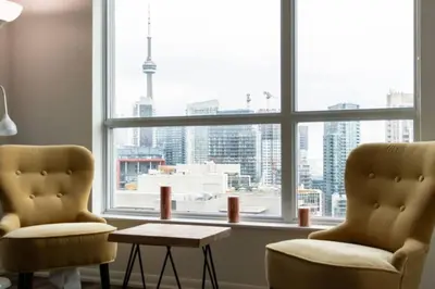 a room with two chairs and a table in front of a window at Chic 1BR Condo Lake and City Views plus Free Parking in Toronto