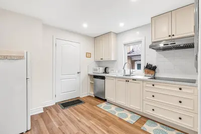 a kitchen with white cabinets and a sink at Cozy 2BR Home with Workspace Toronto Retreat in Toronto
