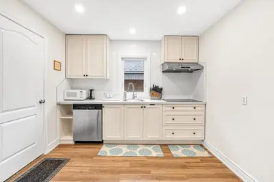 a kitchen with white cabinets and a sink at Cozy 2BR Home with Workspace Toronto Retreat in Toronto