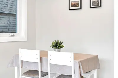 a white dining room table with two white chairs at Cozy 2BR Home with Workspace Toronto Retreat in Toronto