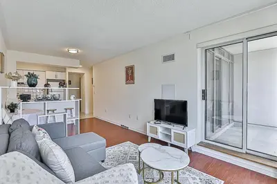 a living room with a couch and a tv at Cozy 1BR Condo with Balcony and Parking in Toronto