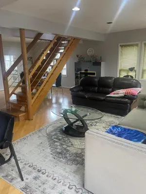 a living room with a couch and a staircase at Homestay Near Victoria Park- FREE WIFI & PARKING-TOP LOCATION in Kitchener