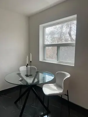 a dining room with a glass table and two chairs at Cozy Bohemian Apartment in Toronto
