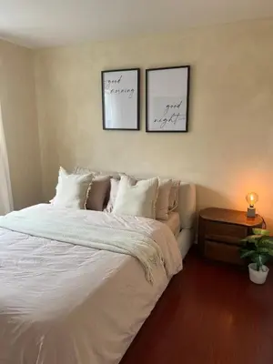 a bedroom with a bed and two pictures on the wall at Cozy Bohemian Apartment in Toronto