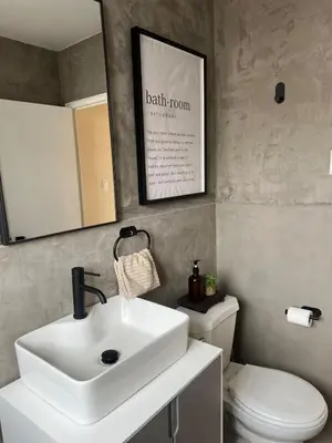 a bathroom with a sink and a toilet and a mirror at Cozy Bohemian Apartment in Toronto