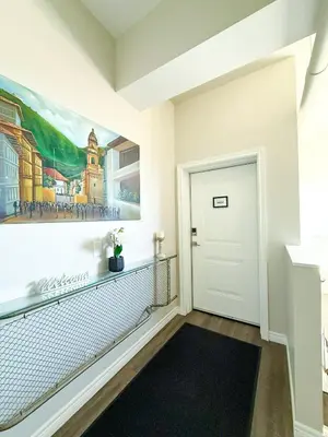a hallway with a door and a painting on the wall at Contemporary East Loft in Historic Niagara in Niagara on the Lake
