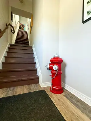 a red fire hydrant sitting next to a staircase at Contemporary East Loft in Historic Niagara in Niagara on the Lake