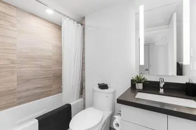 a white bathroom with a toilet and a sink at Executive 1BR-1BA Condo in the heart of downtown in Toronto